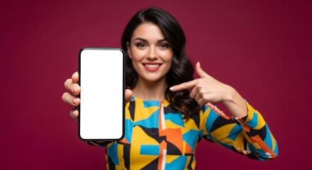 Smiling young woman pointing to blank smartphone screen – mockup space for app, website, or marketing design