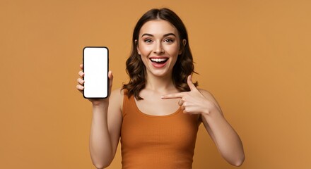 Smiling young woman pointing to blank smartphone screen – mockup space for app, website, or marketing design