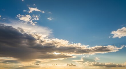 Obraz premium A bright blue sky with fluffy white clouds, some tinged with golden sunlight at the horizon.