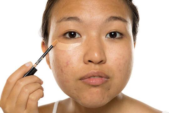 young asian woman apply concealer under the eye.