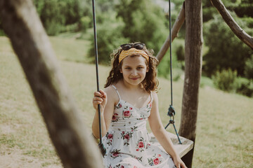Child girl riding on a swing