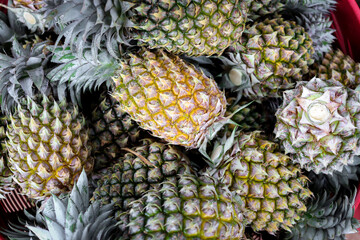 Many ripe pineapple on sell at Asian local market. Tropical sweet delicious fruit