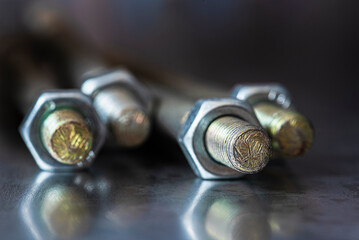 Set of screws lying on a reflective metal surface