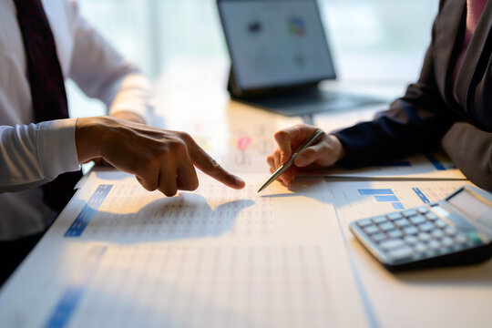 Business colleagues reviewing financial reports and pointing at important data