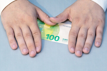 Hands smoothing out a one hundred euro bill on table super close-up, money and savings, investments...
