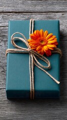 Fototapeta premium Teal gift box decorated with orange flower