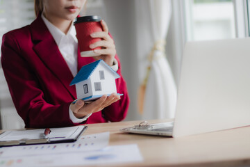 A real estate agent advises a family in an office about signing mortgage and lease documents for...