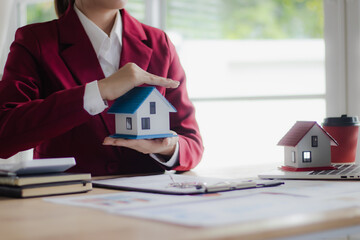 A real estate agent advises a family in an office about signing mortgage and lease documents for...