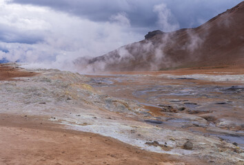 Geothermal activity creates a surreal landscape at Hverir in Namafjall, Iceland with mud pots and steam vents that tourists can watch