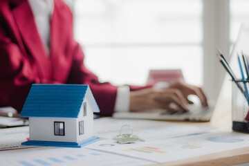  A model of a house placed on a desk in a real estate businessman's office.