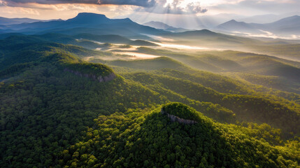 Aerial view of lush green mountains with misty valleys and dramatic clouds. landscape showcases beauty of nature, highlighting serene atmosphere and vibrant foliage