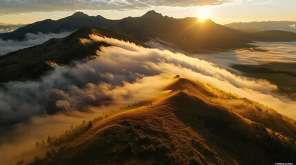Aerial view of majestic mountain peaks rising above sea of clouds during sunrise, creating breathtaking landscape filled with golden light and soft mist