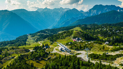 Aerial panoramic view of Velika Planina in Slovenia featuring vast green alpine pastures dotted...