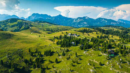 Aerial panoramic view of Velika Planina in Slovenia featuring vast green alpine pastures dotted...