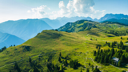 Aerial panoramic view of Velika Planina in Slovenia featuring vast green alpine pastures dotted...