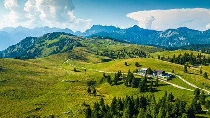 Aerial panoramic view of Velika Planina in Slovenia featuring vast green alpine pastures dotted...