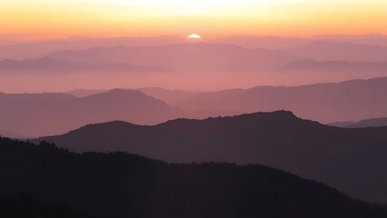 Obraz premium Pink and Purple Mountain Range Sunset Landscape Layers of Hills Silhouetted Against Warm Sky Scenic View