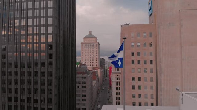 Quebec flag waving in the wind in Montreal, Canada. The flag represents the province's identity and heritage, flying high above the city skyline.