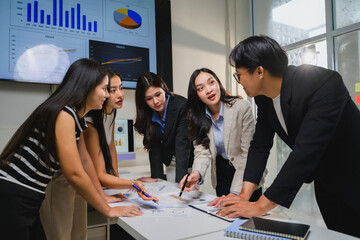 Business team analyzing financial data and discussing marketing strategy in office meeting