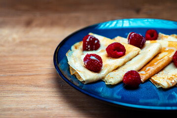 Pancakes with raspberries and condensed milk.
