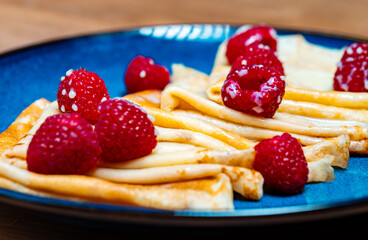 Pancakes with raspberries and condensed milk.