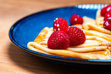 Pancakes with raspberries and condensed milk.