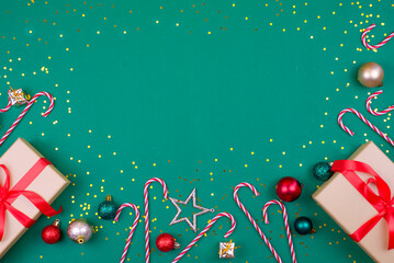 Christmas-themed image featuring gift boxes with red ribbons, candy canes, and ornaments on a green...