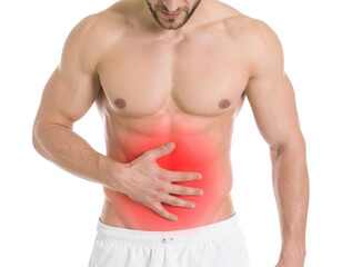 Fototapeta premium A muscular man holding his stomach, indicating discomfort or pain in the abdominal area.
