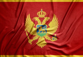 red flag of the European country Montenegro with a beautiful coat of arms on a rough canvas with...