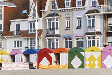 Colorful beach huts in front of historic seaside buildings at Malo-Les-Bains beach in Dunkirk,...