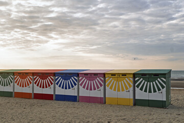 Colorful beach huts in front of historic seaside buildings at Malo-Les-Bains beach in Dunkirk,...