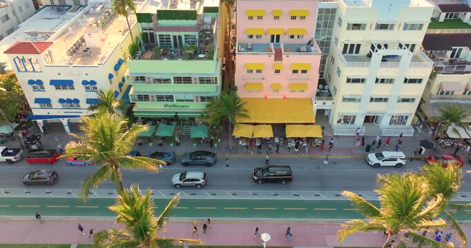 Tourists strolling along colorful Ocean Drive in Miami Beach at sunset. Florida most photographed street.
