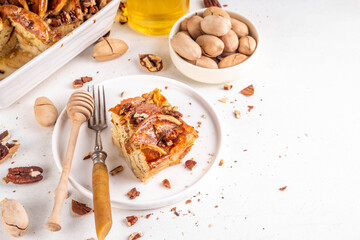 Tasty autumn Cinnamon Pecan Pancake Breakfast baked Casserole with honey. Fall seasonal recipe,  brunch snack for Thanksgiving morning, sweet simple dessert on white table with ingredients for cooking