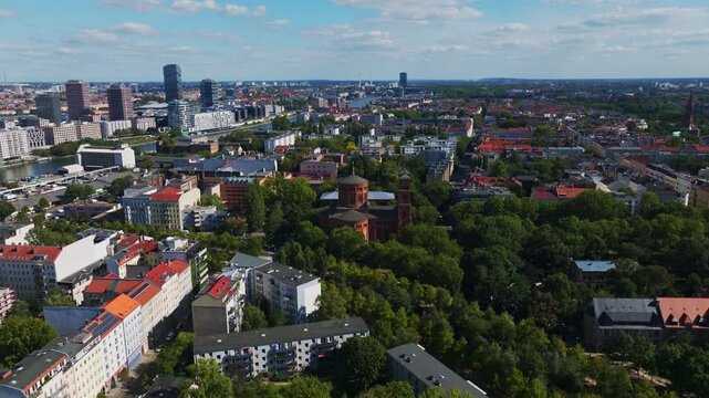Aerial drone view of St. Thomas Church in Berlin, Germany, featuring historic architecture, surrounding city buildings, urban landscape, and scenic skyline on a clear day. 10 September 2024