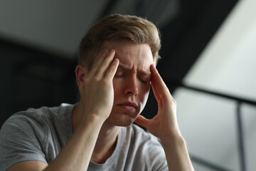 Sad man suffering on blurred background. Depression