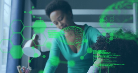 Guiding mother leaning over helping boy navigating tablet in study room with holographic graphics