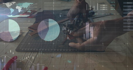 Measuring technician using digital caliper gauging metal part on green mat at workbench, coffee mug