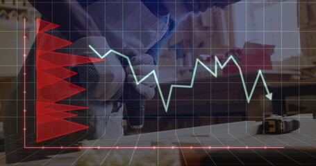 Woodworker in gloves drilling board with power drill in workshop, with red and green overlay graphs