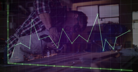 Metalworker wearing gloves using angle grinder on sheet at workshop, with sparks, digital graph