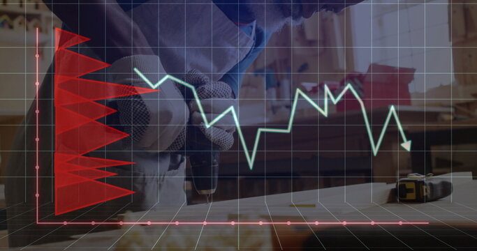Woodworker in gloves drilling board with power drill in workshop, with red and green overlay graphs