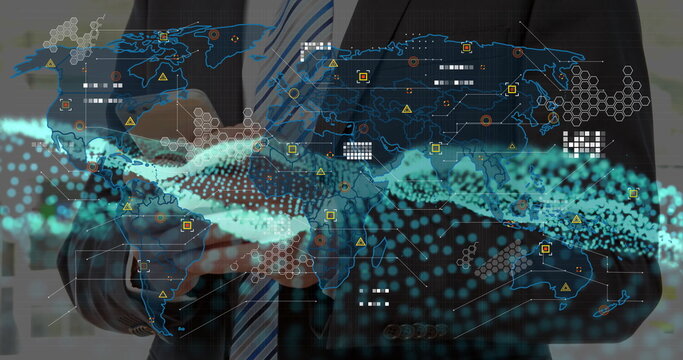 Businessman in suit holding touchscreen and viewing holographic map in office, with streaming data
