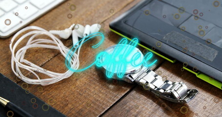 Featuring silver wristwatch resting on home desk, with coiled earphones and neon cyan Coffee text