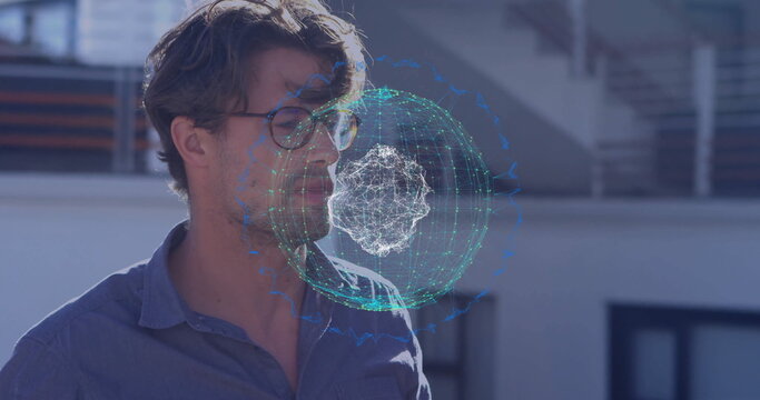 Exploring man wearing blue shirt and glasses using holographic sphere on rooftop, metal railing