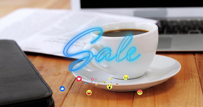 Displaying coffee cup on saucer on office desk beside laptop, showing neon Sale with emojis