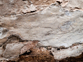 Weathered brown concrete wall with a rough, grungy texture and peeling paint