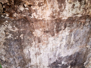 Weathered brown concrete wall with a rough, grungy texture and peeling paint