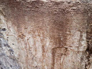 Weathered brown concrete wall with a rough, grungy texture and peeling paint