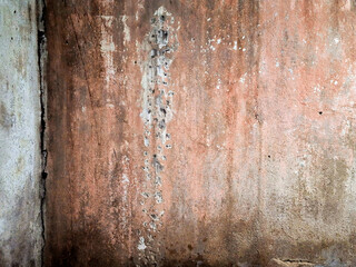 Weathered brown concrete wall with a rough, grungy texture and peeling paint