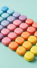 Colorful french macarons arranged in a diagonal gradient of pastel shades on a light blue background isolated on transparent background