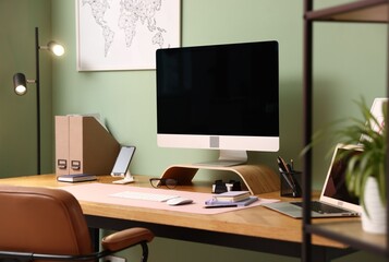 Fototapeta premium Stylish workplace with modern computer, other devices and stationery on wooden desk indoors